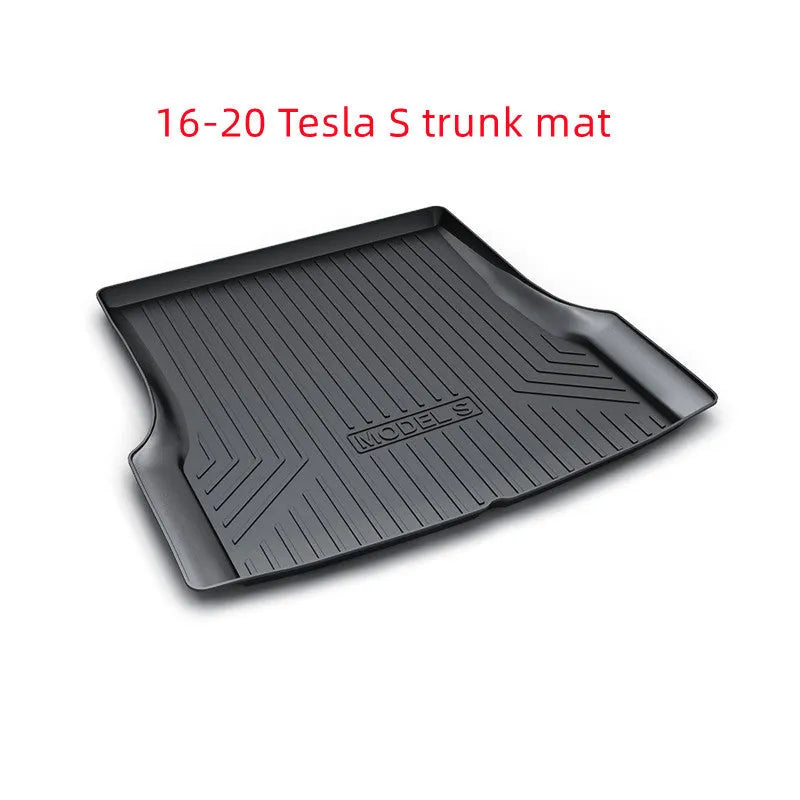 Custom black rubber floor mats fitted in a Tesla Model 3, showing deep grooves and raised edges.