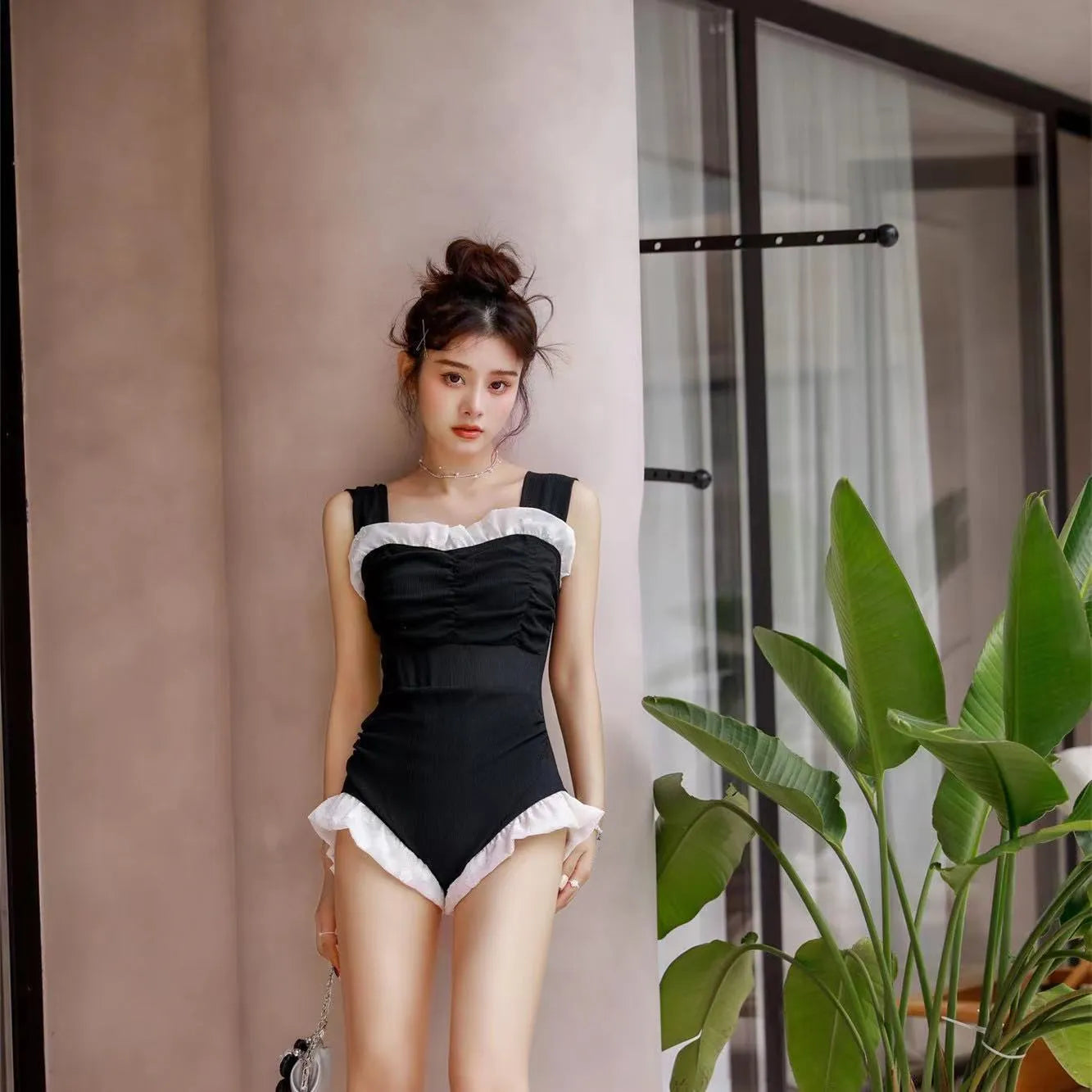 Women's black high-waisted one-piece swimsuit made from quick-drying polyester fabric.