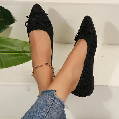 Women's blue knitted loafer flat shoes with a pointed toe and decorative bow detail on the front.