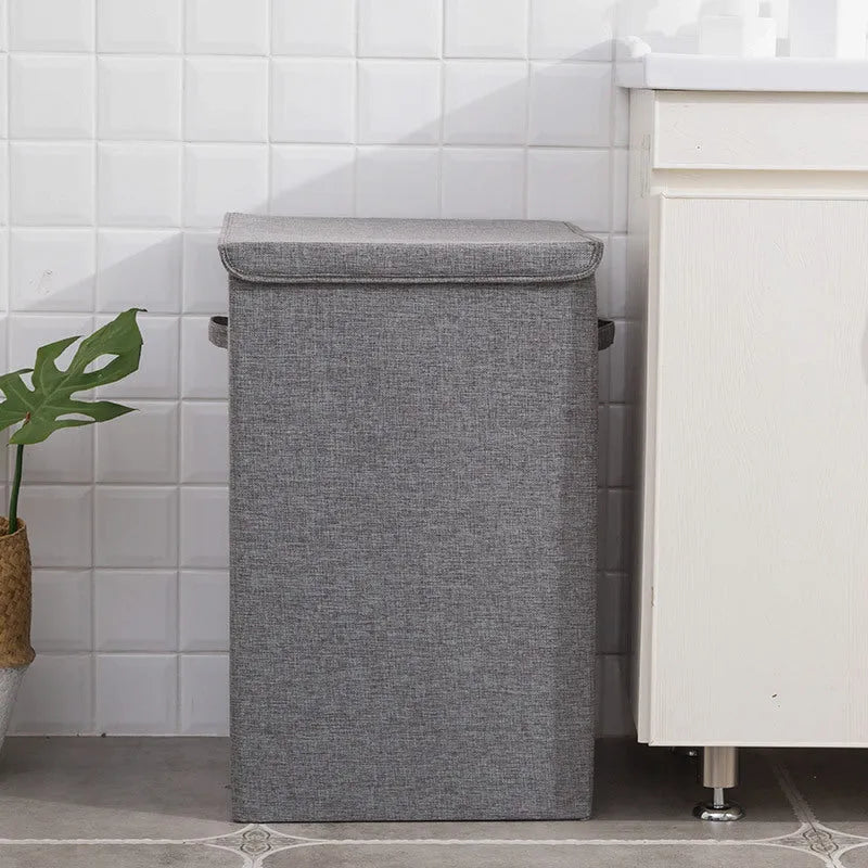 Foldable laundry basket in cotton and linen with a three-dimensional cube design available in brown, grey, or khaki for bedroom or bathroom clothes storage in medium (34x34x58cm) or large (40x40x63cm) sizes.