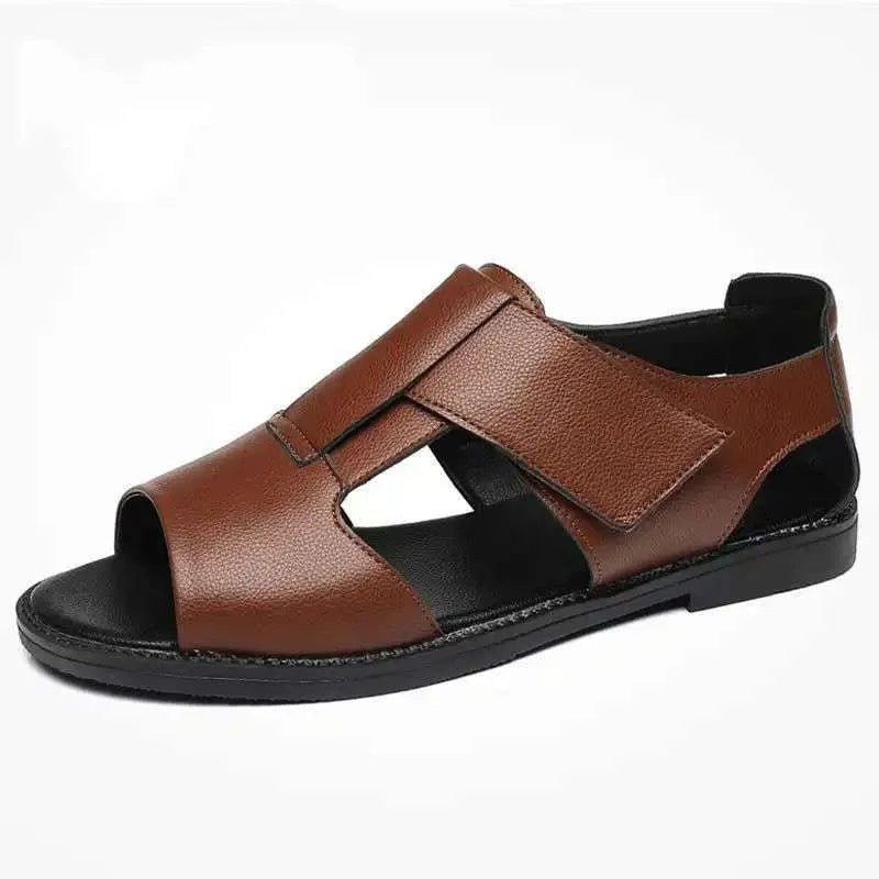 Men's brown leather Roman sandals with an open toe and rubber sole on a wooden surface.