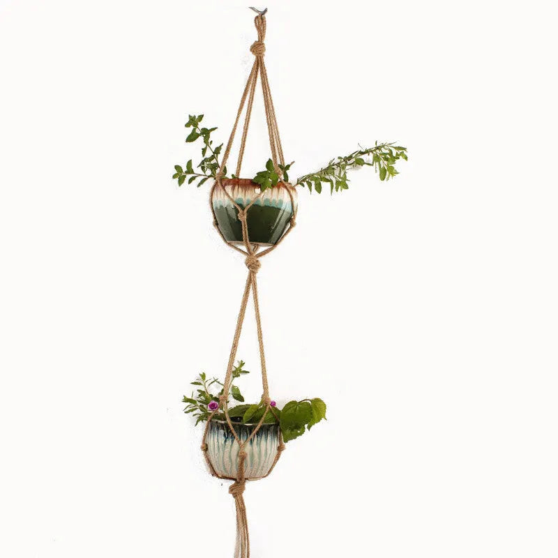 Galvanised steel wire plant basket with open grid, holding a green potted succulent on a wooden table.