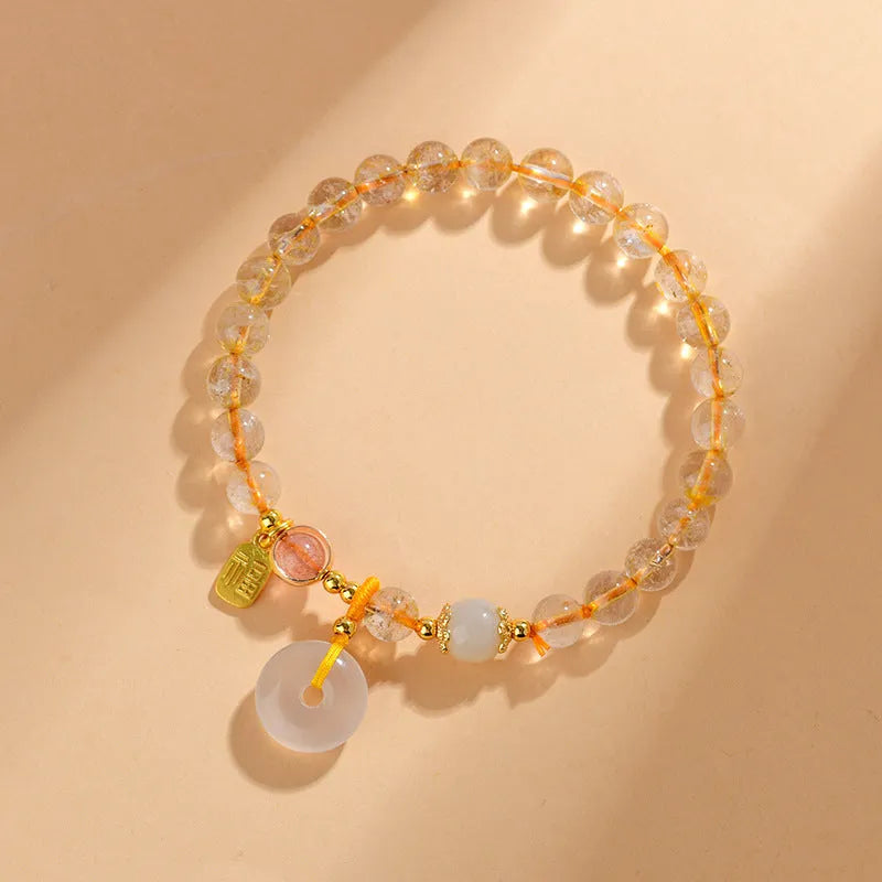 Gold rutilated quartz crystal bracelet with geometric peace buckle pendant and safety clasp