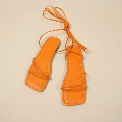 Women's white ankle-ring flat sandals with bandage cloth strap and front lace-up on a rubber sole.