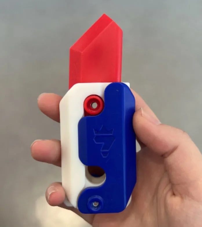3D printed plastic carrot fidget knife with retractable blade, shown in orange and green colour scheme.
