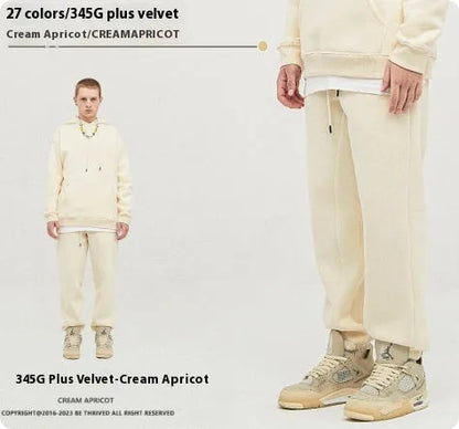 Man wearing solid colour cotton velvet sweatpants with an ankle banded design in a dark grey shade.