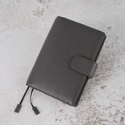 Close-up of a hand-embossed lychee pattern on an off-white A6 cowhide leather notebook with loose-leaf binding.