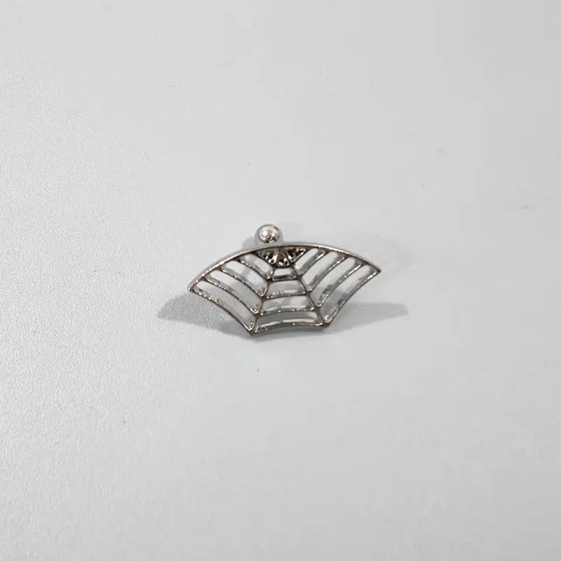Close-up of a geometric spider web design on a gold-toned metal stud earring.