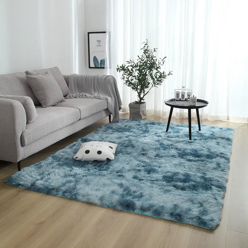 Soft fluffy plain rectangle carpet with anti-slip dots on backing, shown in a light grey colour on a wooden floor.