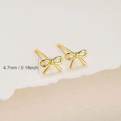 Women's gold bow cross stud earrings in zinc alloy with geometric design