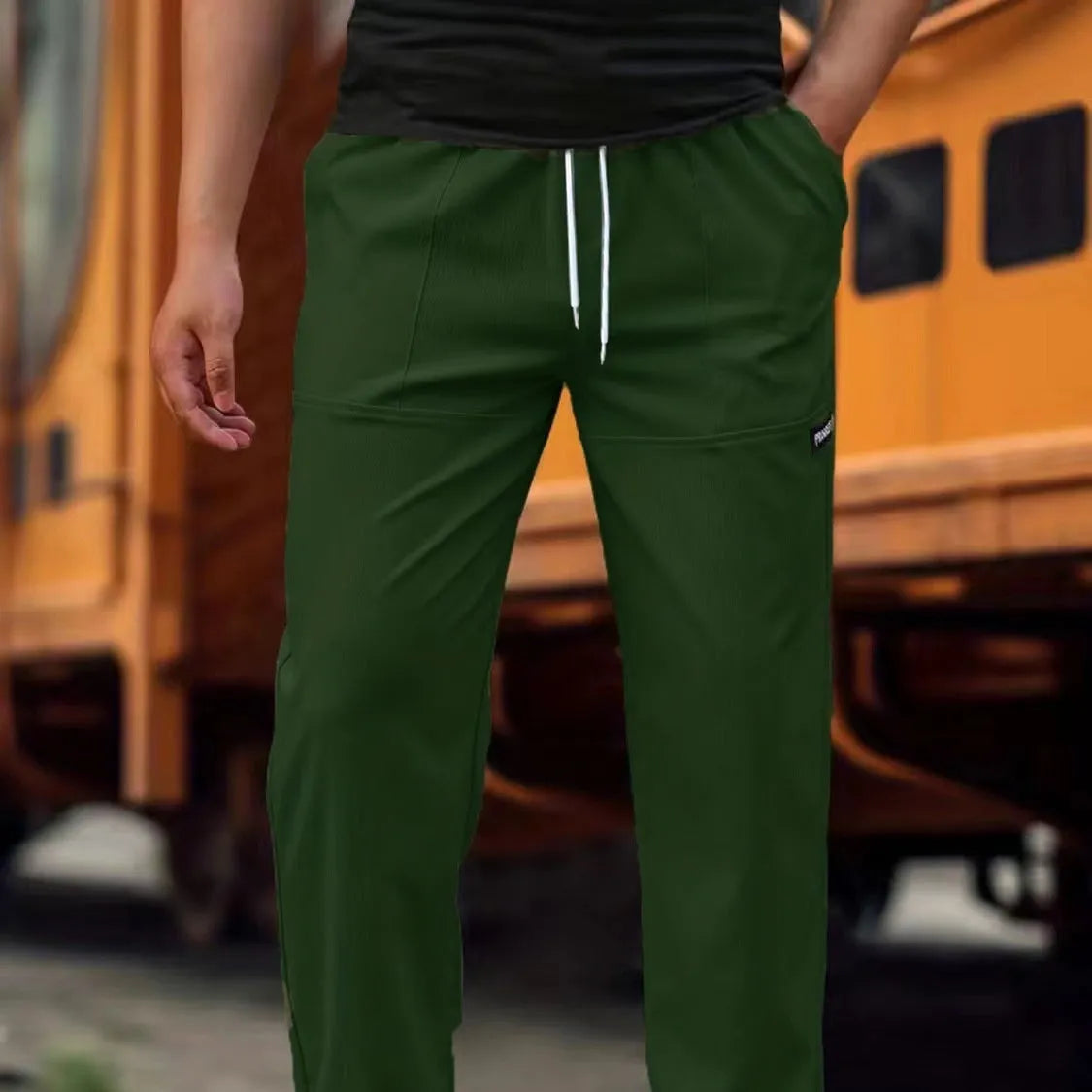 Men's light grey polyester trousers with an elasticated waistband laid flat