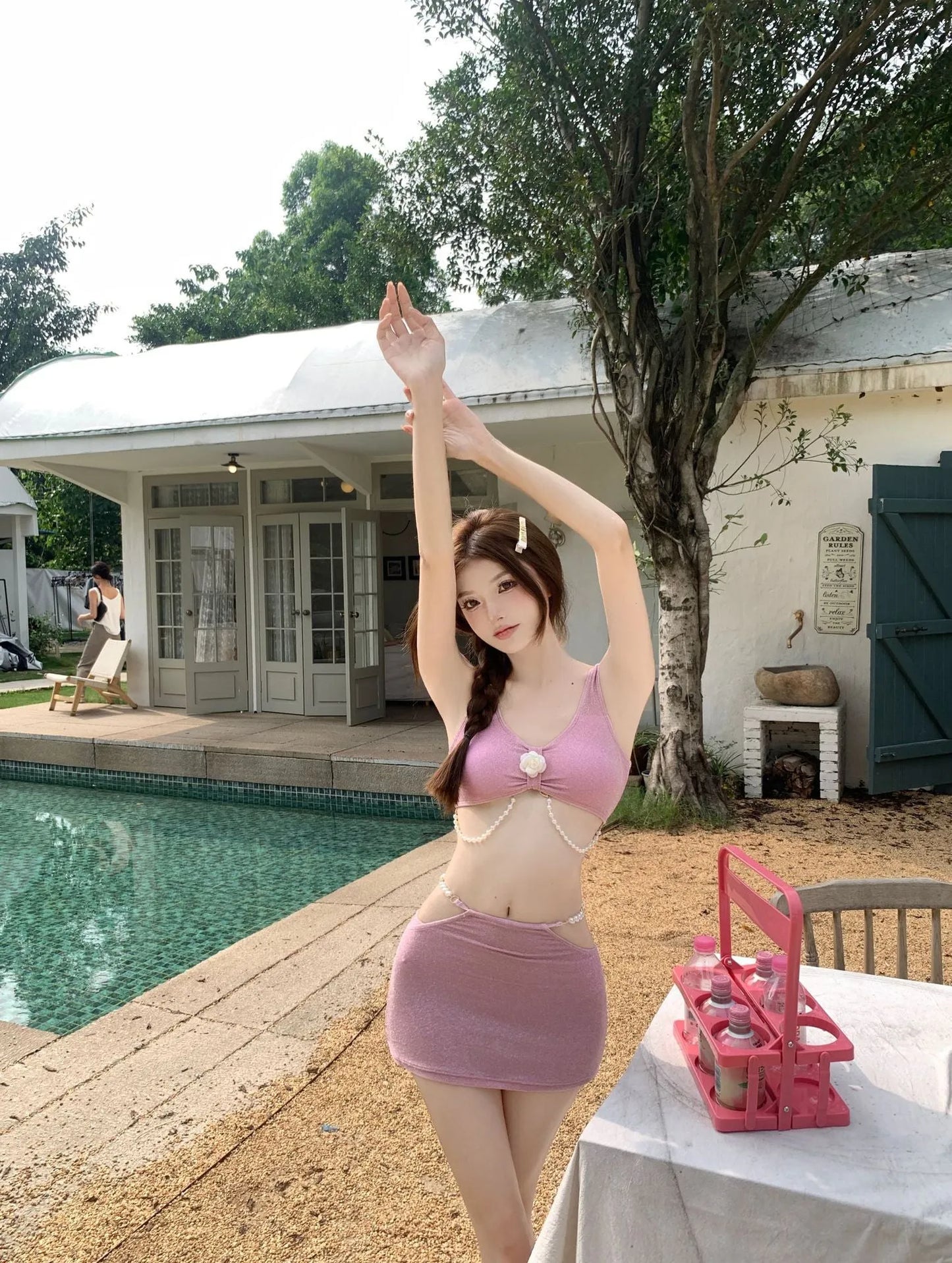 Pink and black polyester three-piece bikini swimsuit on a mannequin
