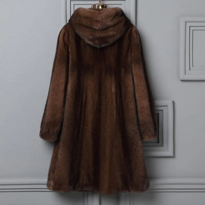 Woman wearing a long black faux fur hooded coat in a street fashion style.