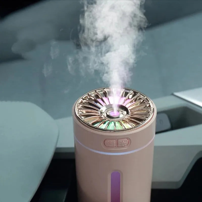 Black portable humidifier with LED lights beside car cup holder showing mist output