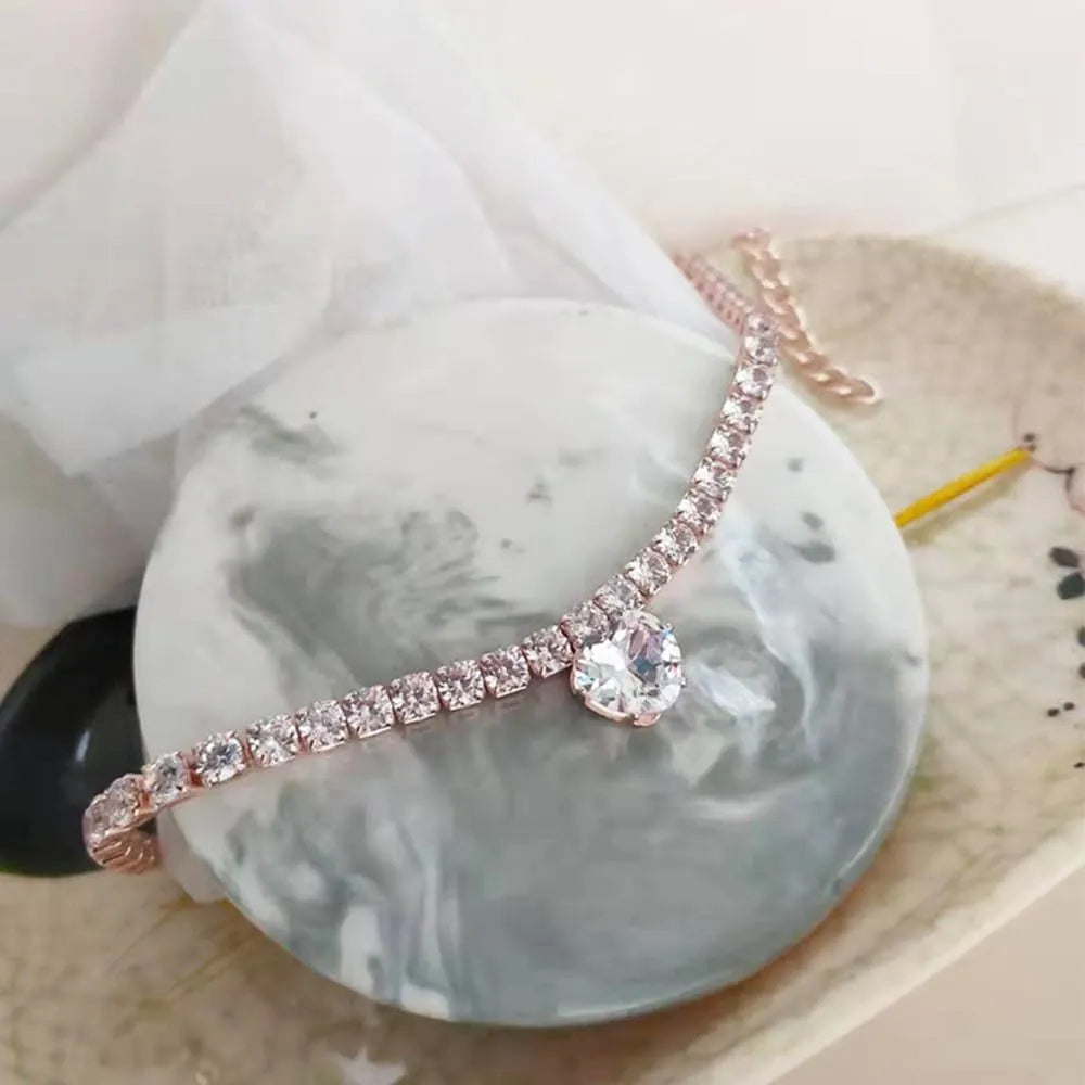 A heart-shaped rhinestone pendant on a gold plated adjustable collar for a small dog, showing the buckle and extension chain.