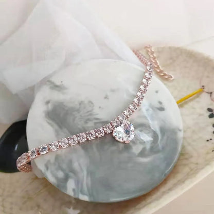 A heart-shaped rhinestone pendant on a gold plated adjustable collar for a small dog, showing the buckle and extension chain.