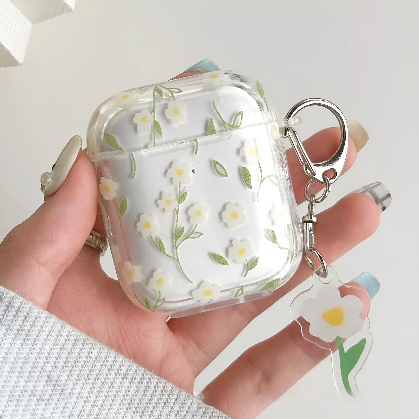 Clear white floral TPU protective cover on an Apple AirPods Pro charging case.