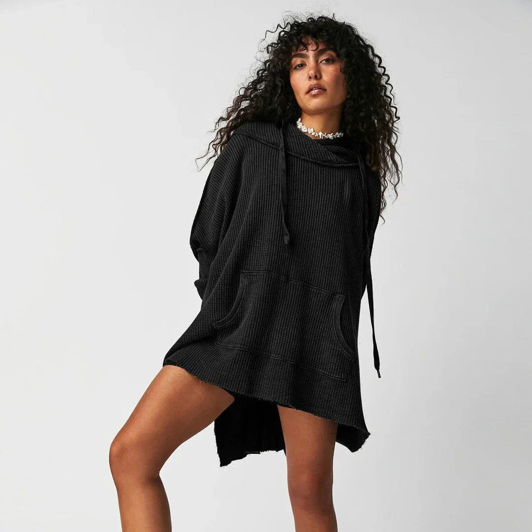 A cosy, oversized black hoodie with pockets, perfect for keeping warm during the autumn and winter seasons in the UK.