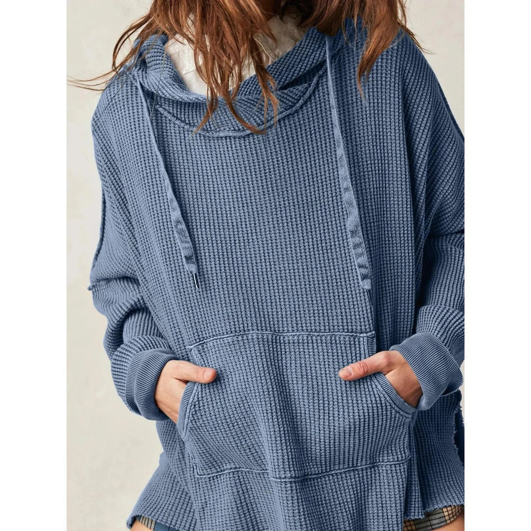 A cosy, oversized black hoodie with pockets, perfect for keeping warm during the autumn and winter seasons in the UK.