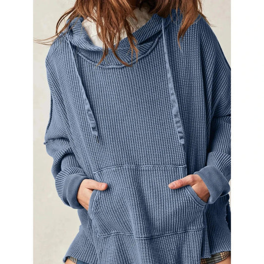 A cosy, oversized black hoodie with pockets, perfect for keeping warm during the autumn and winter seasons in the UK.