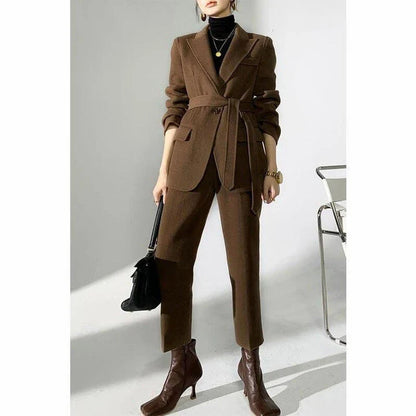 A chic and elegant woolen pant suit in black, featuring a belted jacket and warm trousers perfect for the autumn-winter season.