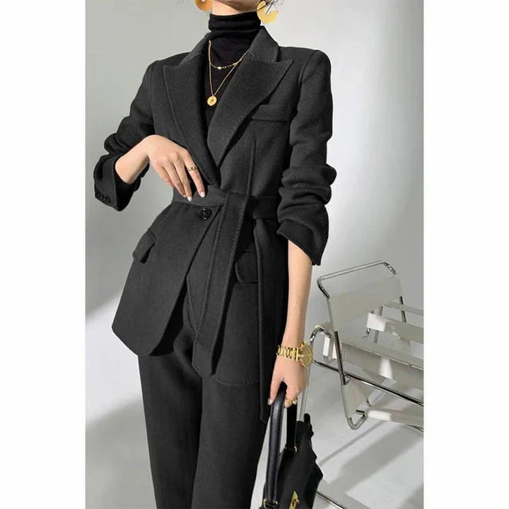 A chic and elegant woolen pant suit in black, featuring a belted jacket and warm trousers perfect for the autumn-winter season.