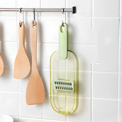Shredded vegetable slicer with stainless steel blades on green cutting board