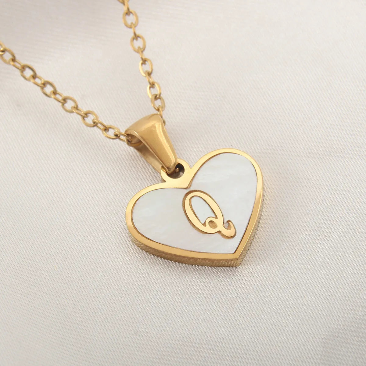 Gold-plated heart necklace with white shell pendant showing letter personalisation option