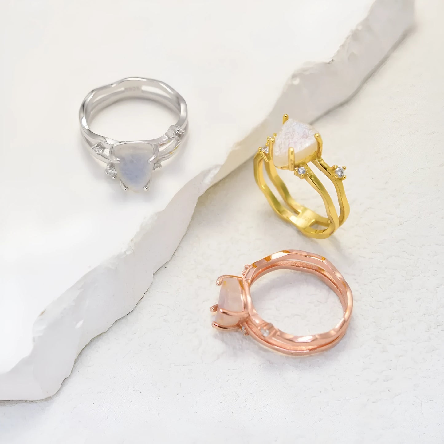 S925 sterling silver ring with an irregular triangular bezel holding a genuine cabochon moonstone, on a model's finger.