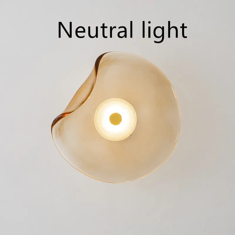 Round glass wall lamp mounted beside bed in cognac colour with 220V operation for bedside lighting
