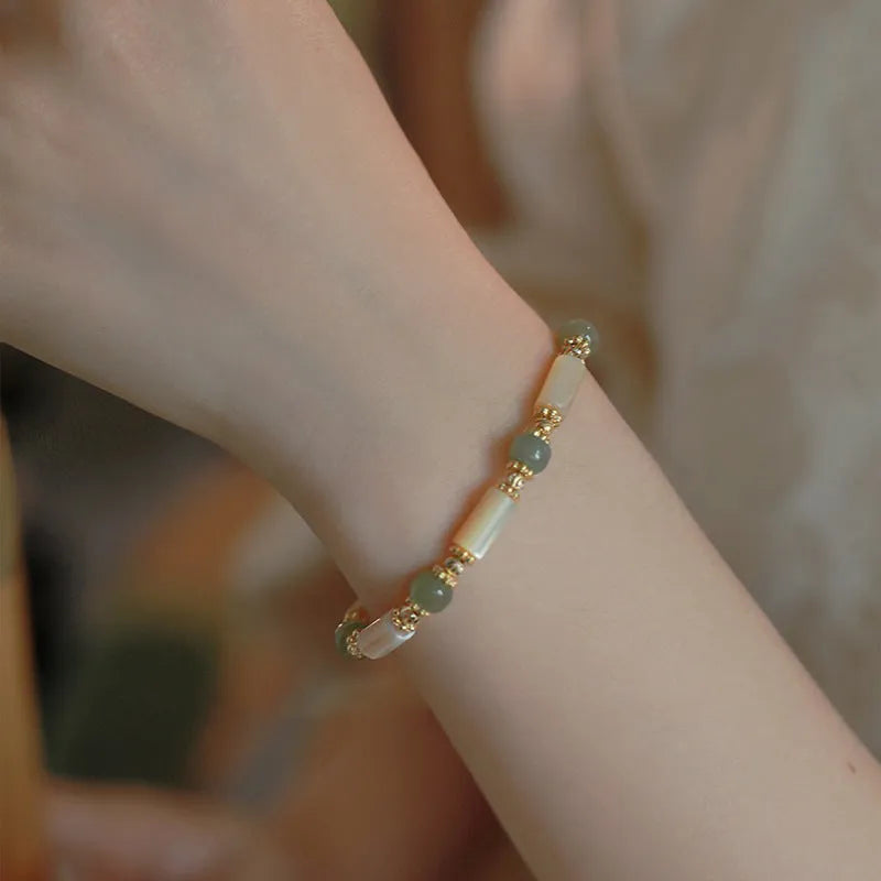 Hetian Jade white lip shell bracelet with geometric round beads on wrist