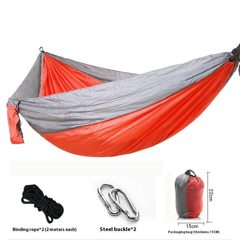 Parachute cloth double camping hammock in chosen colour, with black buckles and round ropes on a tree.