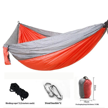 Parachute cloth double camping hammock in chosen colour, with black buckles and round ropes on a tree.