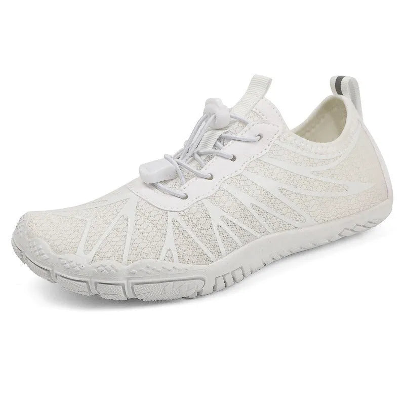 Men's and women's low-top breathable sports running shoes with a natural rubber sole on a hard ground surface.