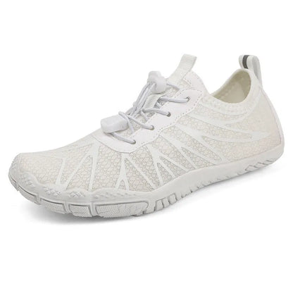 Men's and women's low-top breathable sports running shoes with a natural rubber sole on a hard ground surface.
