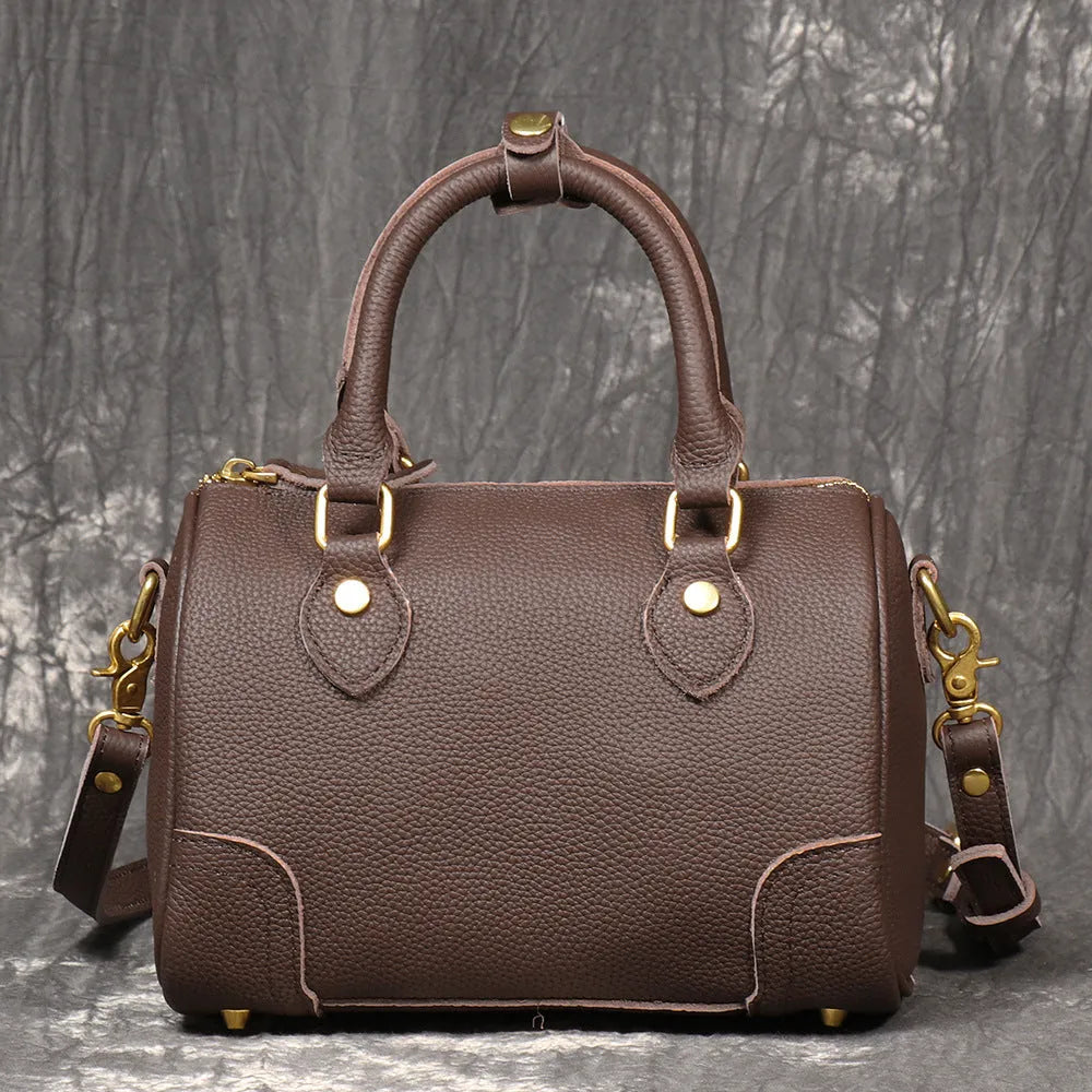Handmade cylindrical brown Boston bag made from first layer cowhide leather with a single shoulder strap.