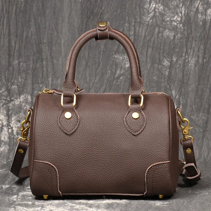 Handmade cylindrical brown Boston bag made from first layer cowhide leather with a single shoulder strap.