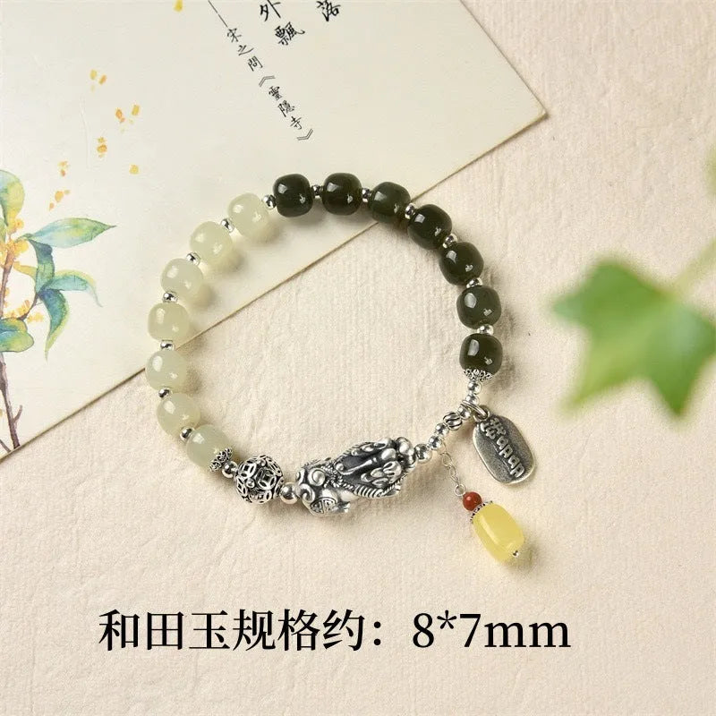 Close-up of a retro-style sterling silver coin bracelet with natural Hetian jade beads for women.
