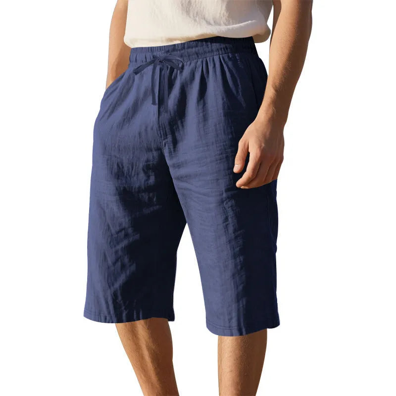 Men's loose-fit linen shorts in a solid colour with a drawstring waist and cropped leg length.