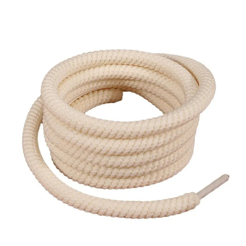 Round woven white, beige, and black shoelaces for bread shoes showing different lengths on a flat surface.