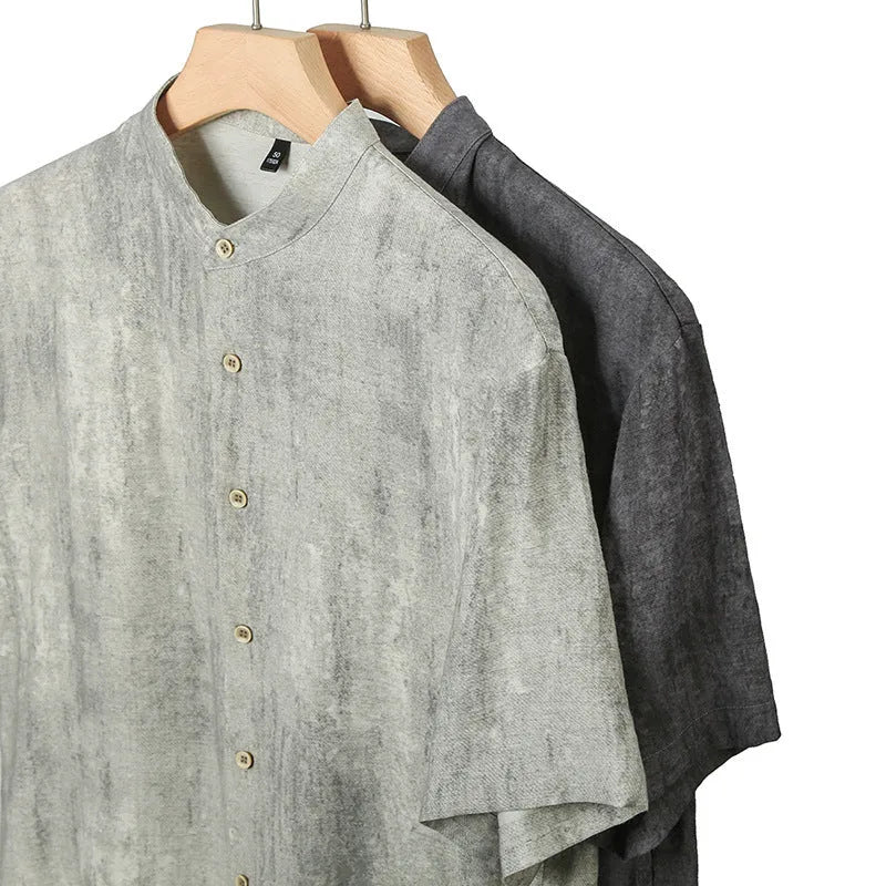 Man wearing a loose-fit grey linen blend short-sleeve shirt with a stand collar.