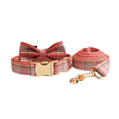 Red plaid cloth dog collar and leash set with matching bow on a white background