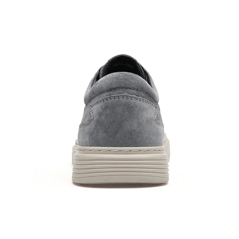 Men's grey low-top casual leather skate shoes with round toe and flat rubber sole on a plain background.