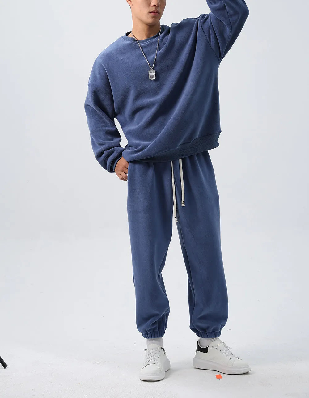 Man wearing a loose-fit army green polar fleece tracksuit with a crew neck jacket and matching padded trousers.