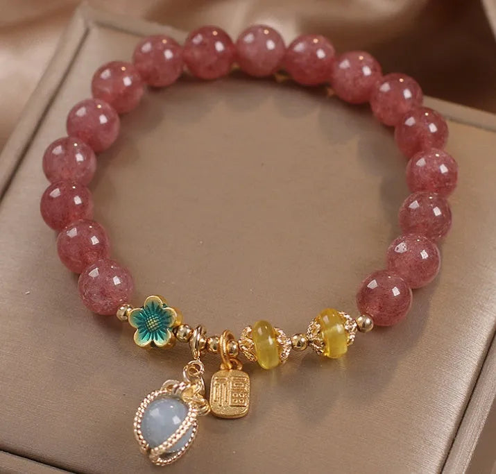 Red beaded bracelet with strawberry quartz gems, alloy clasp, and rhinestone details.