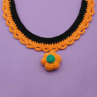 Hand-crocheted wool pet collar in pumpkin colour for a dog or cat, showing adjustable size and textured yarn.