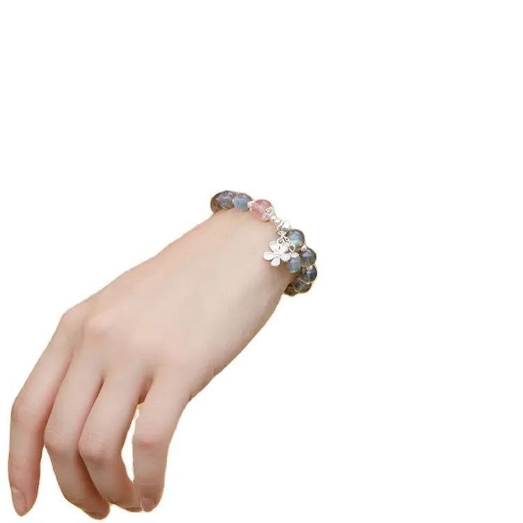 Close-up of a women's 925 silver bracelet with a 7.5mm grey moonlight strawberry stone and honeysuckle zodiac design.