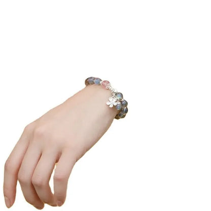 Close-up of a women's 925 silver bracelet with a 7.5mm grey moonlight strawberry stone and honeysuckle zodiac design.