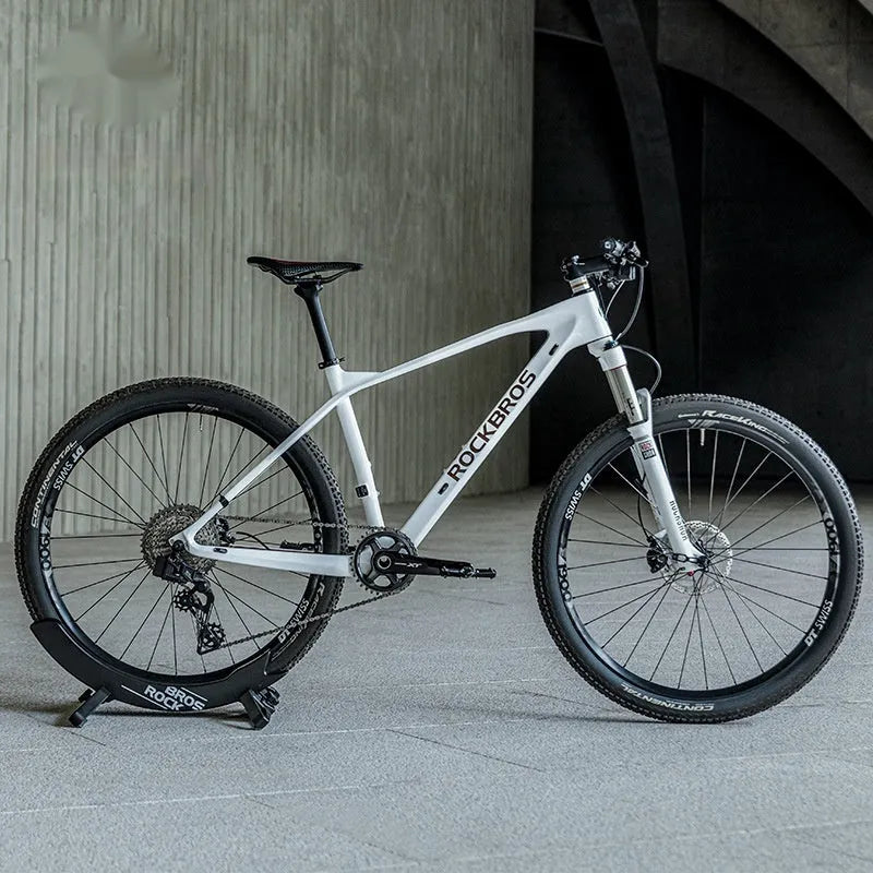 A black wall-mounted ABS plastic bracket holding a mountain bike vertically for storage.