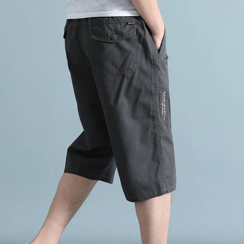 Man wearing loose grey cotton sports pants with a straight leg and cropped length.